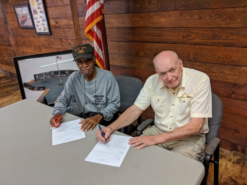 Fallen Veterans Monument committee members Cecil Hooker, left, and Ray Crocker sign the order form for the new monument. The new monument is expected to be delivered and set up in time for Veterans Day on November 11.